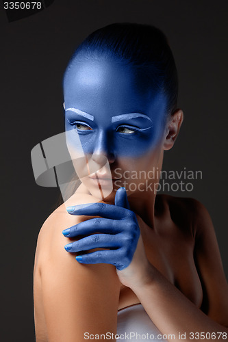 Image of Portrait of a woman who is posing covered with blue paint