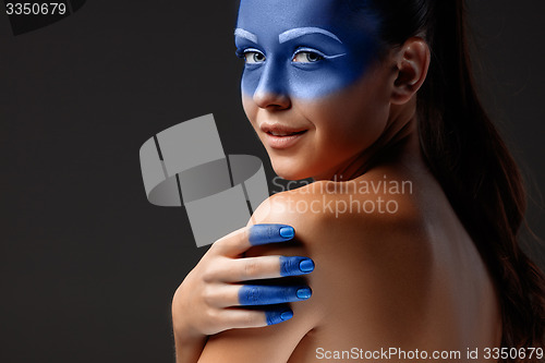 Image of Portrait of a woman who is posing covered with blue paint