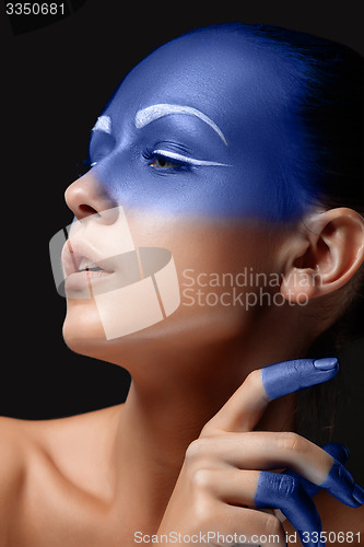 Image of Portrait of a woman who is posing covered with blue paint