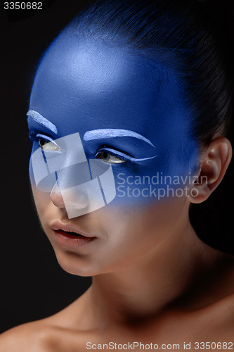 Image of Portrait of a woman who is posing covered with blue paint