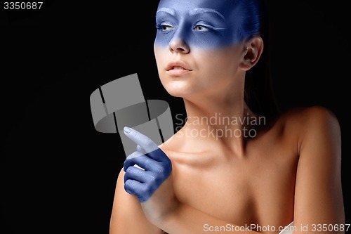 Image of Portrait of a woman who is posing covered with blue paint