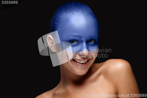 Image of Portrait of a woman who is posing covered with blue paint