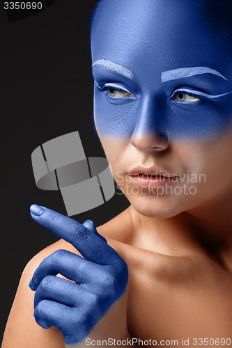 Image of Portrait of a woman who is posing covered with blue paint