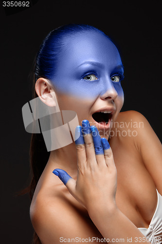 Image of Portrait of a woman who is posing covered with blue paint