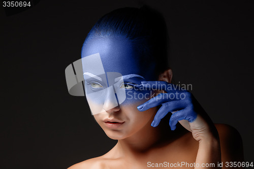 Image of Portrait of a woman who is posing covered with blue paint