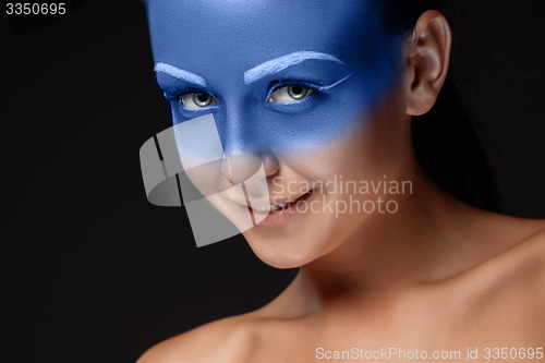 Image of Portrait of a woman who is posing covered with blue paint