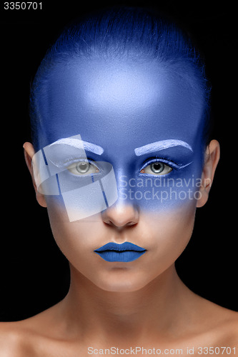 Image of Portrait of a woman who is posing covered with blue paint