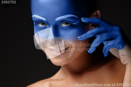 Image of Portrait of a woman who is posing covered with blue paint