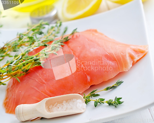 Image of Raw salmon on the white plate with thyme and salt