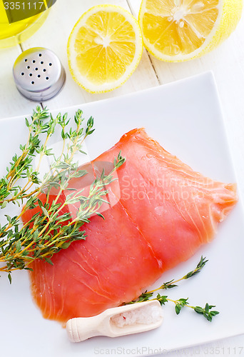 Image of Raw salmon on the white plate with thyme and salt