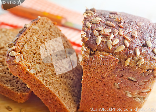 Image of Fresh bread and knife on the wooden board