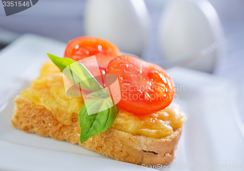 Image of bread with cheese,tomato and basil