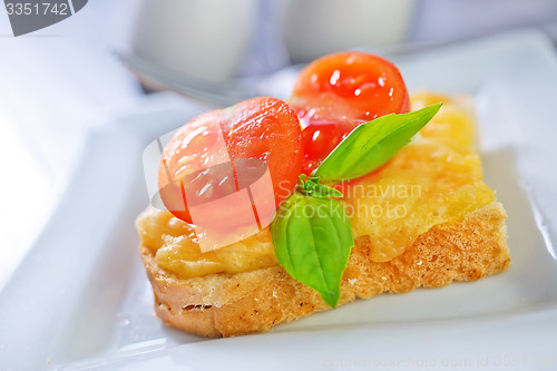 Image of bread with cheese,tomato and basil