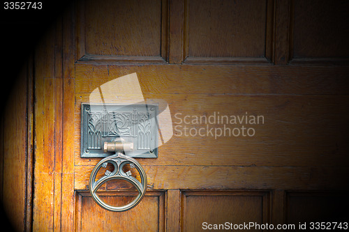 Image of handle in london antique brown door  rusty  brass nail and light