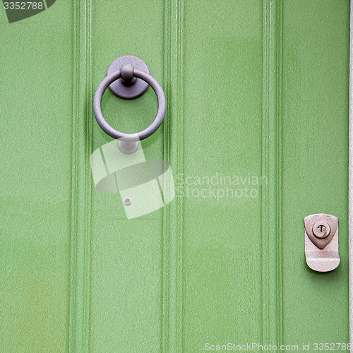 Image of green  handle in london antique brown door  rusty  brass nail an