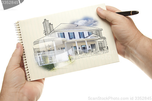 Image of Hands Holding Pen and Pad of Paper with House Drawing