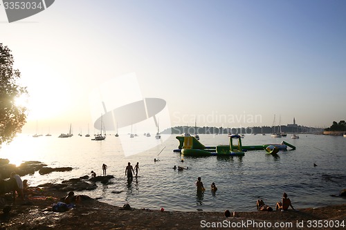 Image of Tourists sunbathing at sunset