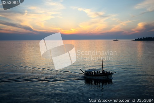 Image of Boat sailing at sunset