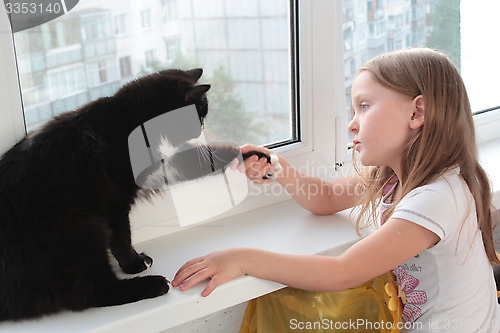 Image of little girl associates with black cat
