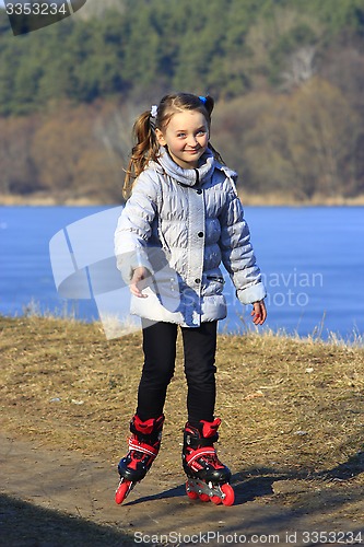 Image of teenager girl goes in roller skates on the ground