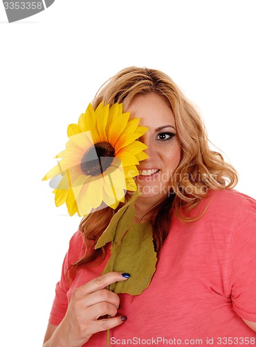 Image of Woman holding sunflower for one eye.