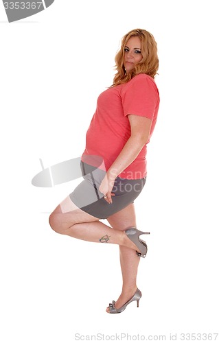 Image of Plus size woman standing in shorts and heels.