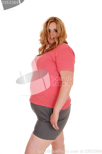 Image of Young plus size woman standing in shorts.