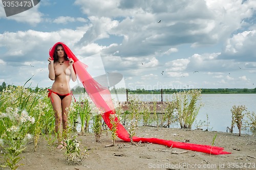 Image of Attractive topless girl on river bank