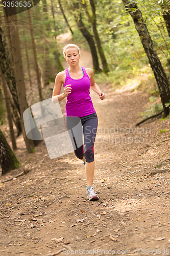 Image of Pretty young girl runner in the forest. 