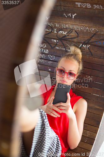 Image of Young cheerful woman using smarthphone.