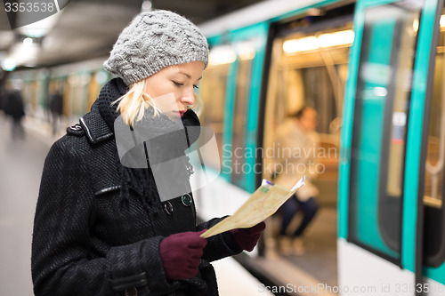 Image of Lady waiting on subway station platform.