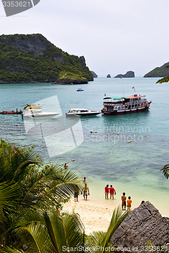 Image of  boat coastline of a  green lagoon and people