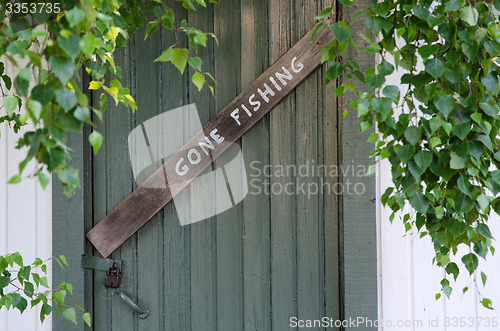 Image of Gone Fishing sign at on old door