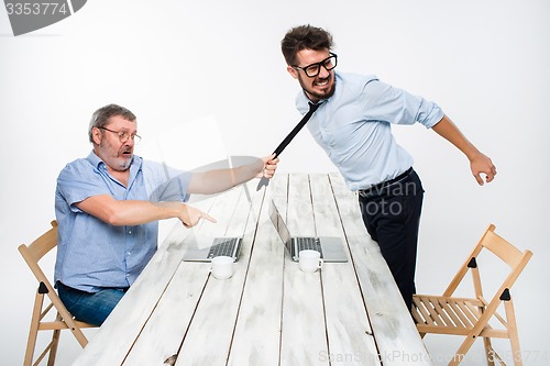 Image of Business conflict. The two men expressing negativity while one man grabbing the necktie of her opponent