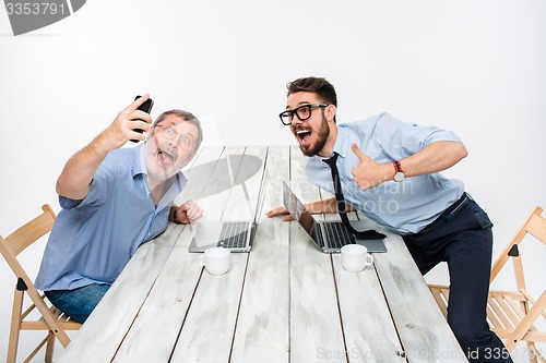 Image of Two colleagues  taking the picture to them self sitting in office