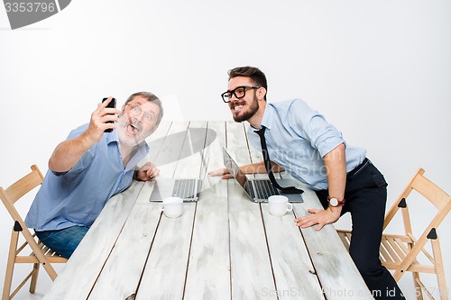 Image of Two colleagues  taking the picture to them self sitting in office