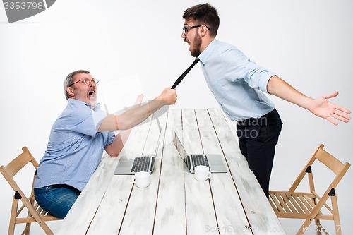 Image of Business conflict. The two men expressing negativity while one man grabbing the necktie of her opponent