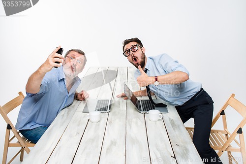 Image of Two colleagues  taking the picture to them self sitting in office