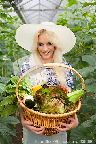 Image of Attractive blond woman with a basket of vegetables