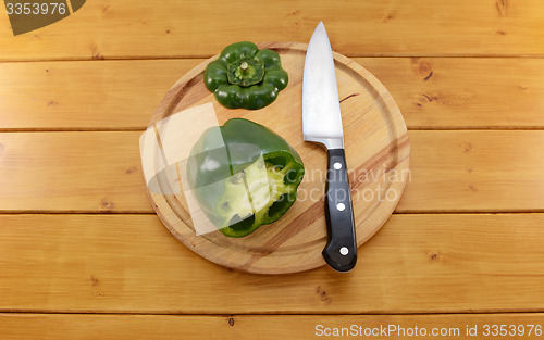 Image of Green pepper sliced open with a knife on a chopping board