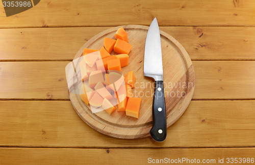 Image of Chopped butternut squash with a knife on a chopping board 