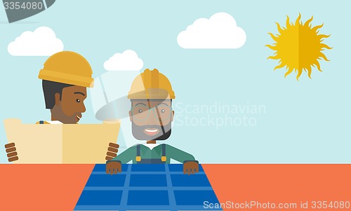 Image of African man putting a solar panel on the roof.