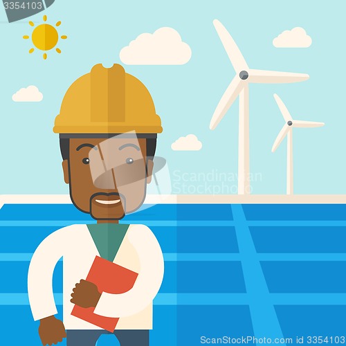 Image of Black man in solar panel and windmills.