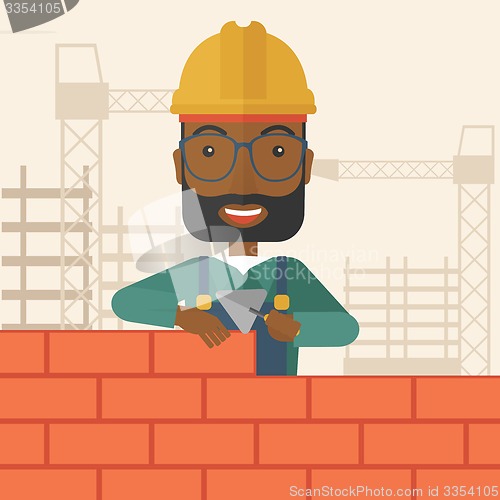 Image of Black builder man is building a brick wall.