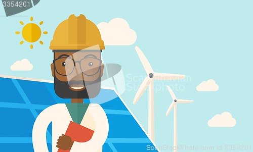 Image of Black man in solar panel and windmills.