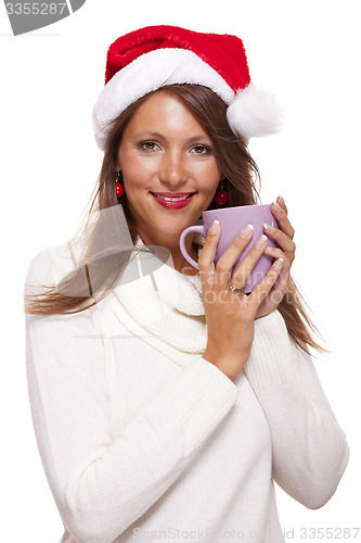 Image of Cold young woman in a Santa hat sipping coffee tea
