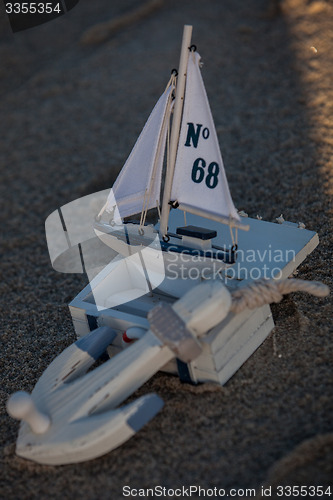 Image of sailing boat and seashell in sand decoration closeup