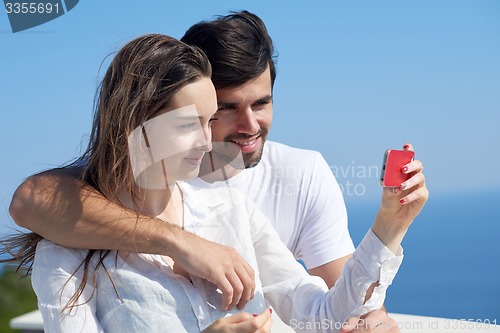 Image of young couple taking selfie with phone