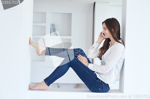 Image of young woman using cellphone at home