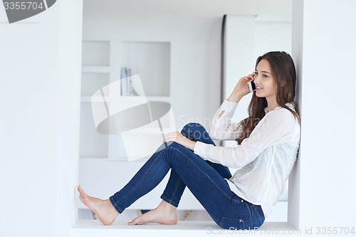 Image of young woman using cellphone at home